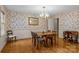 Traditional dining room with hardwood floors, floral wallpaper and chandelier lighting at 3209 Sedgefield Rd, Statesville, NC 28625