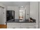 Well-lit kitchen featuring an electric cooktop and black refrigerator and view to adjacent room at 3209 Sedgefield Rd, Statesville, NC 28625