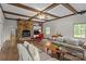 Cozy living room with exposed wood beams, brick fireplace, hardwood floors, and comfortable seating at 3209 Sedgefield Rd, Statesville, NC 28625