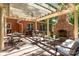 Covered patio featuring an outdoor fireplace, dining set, seating area, and lush landscaping at 3209 Sedgefield Rd, Statesville, NC 28625