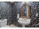 Stylish powder room with unique butterfly wallpaper, pedestal sink, and elegant gold mirror at 3209 Sedgefield Rd, Statesville, NC 28625