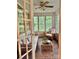 Inviting sunroom with brick floors, large windows, and comfortable wicker furniture at 3209 Sedgefield Rd, Statesville, NC 28625