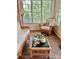 Sunroom features brick floors, wicker furniture, coffee table and large windows bringing nature indoors at 3209 Sedgefield Rd, Statesville, NC 28625