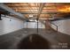Unfinished basement featuring concrete floors, white brick walls, exposed beams, and stairs at 344 Lucas Rd, Star, NC 27356
