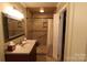 Bathroom with tiled shower, shower curtain, modern sink, and decorative mirror at 344 Lucas Rd, Star, NC 27356