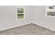 Empty bedroom with neutral walls, wood floors and two windows providing natural light at 4108 Mellon Rd, Matthews, NC 28104