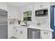 Bright kitchen with white cabinets, stainless steel appliances, and a window overlooking a lush green view at 4108 Mellon Rd, Matthews, NC 28104