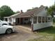 Back of home featuring a long carport, a sunroom, and a white exterior at 5004 King Wilkinson Rd, Denver, NC 28037