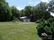 View of detached garage with two bays and plenty of surrounding foliage at 5004 King Wilkinson Rd, Denver, NC 28037