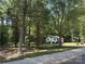 A quaint house partially obscured by trees viewed from across the street at 555 Ridge Ave, Mooresville, NC 28115