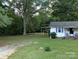 Expansive front yard with mature trees offering shade and privacy to the home at 555 Ridge Ave, Mooresville, NC 28115