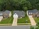 Beautiful aerial view of suburban homes featuring manicured lawns, driveways, and lush green trees at 5748 Timbertop Ln, Charlotte, NC 28215