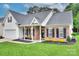 Charming home with a brick facade, black shutters, manicured landscaping, and covered front porch at 5748 Timbertop Ln, Charlotte, NC 28215