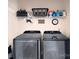 This laundry room has a new washer, dryer, and storage shelf at 5748 Timbertop Ln, Charlotte, NC 28215