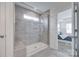 Modern bathroom featuring a sleek glass-enclosed shower with gray tile, a built-in niche, and wood look tile flooring at 5836 Clan Maclaine Dr, Charlotte, NC 28278