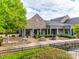 Beautiful community clubhouse featuring a stone facade, outdoor seating, and well-maintained landscaping at 5836 Clan Maclaine Dr, Charlotte, NC 28278
