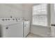 Convenient laundry room with modern washer, dryer, and storage shelf at 5836 Clan Maclaine Dr, Charlotte, NC 28278