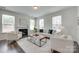 Bright living room featuring a cozy fireplace, neutral furniture, and plenty of natural light from large windows at 5836 Clan Maclaine Dr, Charlotte, NC 28278