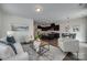 Open-concept living room showcasing hardwood floors, comfortable seating, and a modern kitchen in the background at 5836 Clan Maclaine Dr, Charlotte, NC 28278