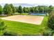 Outdoor sand volleyball court with a tennis court and playground in the background is surrounded by green lawn at 5836 Clan Maclaine Dr, Charlotte, NC 28278
