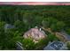 Expansive aerial view of wooded property showcasing large home with water feature at 5915 Vidal Ln, Charlotte, NC 28226