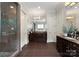 Bathroom featuring double vanities, a glass shower, and modern lighting at 5915 Vidal Ln, Charlotte, NC 28226