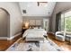 Spacious bedroom with a tray ceiling, natural light, and a cozy bench at 5915 Vidal Ln, Charlotte, NC 28226