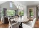 Bright dining area with a marble table, large windows overlooking the backyard, and stylish pendant lighting at 5915 Vidal Ln, Charlotte, NC 28226