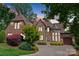 Stunning front exterior showcasing a stone and brick facade, turret, and a circular driveway at 5915 Vidal Ln, Charlotte, NC 28226
