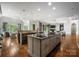 Expansive open concept kitchen with island seating, modern appliances, and hardwood floors flowing to other rooms at 5915 Vidal Ln, Charlotte, NC 28226