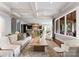 Open-concept living room with hardwood floors, coffered ceilings, and seamless flow into other rooms at 5915 Vidal Ln, Charlotte, NC 28226