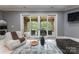 Neutral living room with lots of natural light and view to stone covered patio and a glimpse of nature at 5915 Vidal Ln, Charlotte, NC 28226