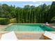 Beautiful backyard pool surrounded by lush greenery, featuring a waterfall feature and lounge chairs at 5915 Vidal Ln, Charlotte, NC 28226