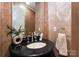 Powder room with a granite countertop sink and decorative wallpaper at 5915 Vidal Ln, Charlotte, NC 28226