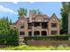 Stately brick home with a stone accent rear exterior, covered patio, and beautifully landscaped yard at 5915 Vidal Ln, Charlotte, NC 28226