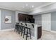 Basement wet bar offers seating for five, granite countertops, and full sized refrigerator perfect for entertaining at 5915 Vidal Ln, Charlotte, NC 28226