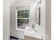 Small bathroom with white fixtures, natural light from the window, and retro wallpaper at 592 Woodcrest Dr, Gastonia, NC 28056