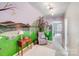 Unique bedroom featuring a whimsical mural, comfortable armchair, and ample natural light at 592 Woodcrest Dr, Gastonia, NC 28056