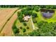 Aerial view of property surrounded by a blend of trees, open fields, and a pond, offering a tranquil and private setting at 6300 Mount Pleasant S Rd, Concord, NC 28025
