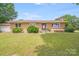 Charming brick home featuring a well-maintained lawn, complemented by mature greenery, and a welcoming front entrance at 6300 Mount Pleasant S Rd, Concord, NC 28025