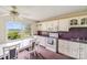 Bright kitchen with white cabinets, purple countertops and accents, white appliances and dining table at 6300 Mount Pleasant S Rd, Concord, NC 28025