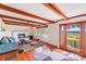 Cozy living room with hardwood floors, exposed beams, fireplace, and scenic backyard views at 6300 Mount Pleasant S Rd, Concord, NC 28025