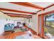 Cozy living room with exposed wood beams, a fireplace and a large window showcasing the view of the property at 6300 Mount Pleasant S Rd, Concord, NC 28025