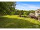 Expansive backyard featuring a lush lawn, mature trees, and a charming patio area at 6409 Barkley Farm Rd, Huntersville, NC 28078