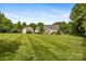 Expansive backyard featuring a well-maintained lawn, mature trees, and inviting outdoor spaces at 6409 Barkley Farm Rd, Huntersville, NC 28078