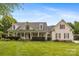 Charming home featuring a large front lawn and inviting front porch with classic architectural detailing at 6409 Barkley Farm Rd, Huntersville, NC 28078