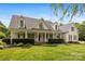 Charming two-story home with a manicured lawn and a welcoming covered front porch at 6409 Barkley Farm Rd, Huntersville, NC 28078
