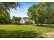Sprawling lawn surrounds this two-story home with lush landscaping and mature trees at 6409 Barkley Farm Rd, Huntersville, NC 28078