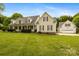 Inviting two-story home with a manicured lawn and a charming covered front porch at 6409 Barkley Farm Rd, Huntersville, NC 28078