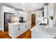 Modern kitchen with white cabinets, stainless steel appliances, a center island with a cooktop, and hardwood floors at 6409 Barkley Farm Rd, Huntersville, NC 28078